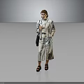 Woman In Light Gray Jumpsuit With Belt Holding Black Handbag Standing Against Dark Background