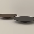 Two Brown and Black Ceramic Plates with Minimalist Design on Light Background