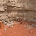 Natural Weathered Rocky Terrain With Red Sandy Ground And Scattered Small Stones