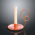 Decorative Copper Candlestick Holder With Curved Design And Lit White Candle