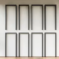 Eight Black Frames Arranged Neatly On White Wall With Wooden Floor