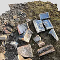 Scattered Broken Bricks And Stones On Grassy Ground With Natural Debris