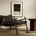 Black Leather Armchair With Wooden Frame And Side Table On Round Rug With Wall Art