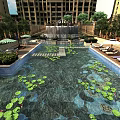 Beautiful Water Fountain In Modern Building Complex With Pool Water Lily Leaves Loungers And Trees