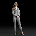 Professional Woman in Gray Suit With White Shirt and Ponytail Standing Against Black Background