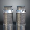 Two Silver Metal Milk Cans on Reflective Surface with Dark Background
