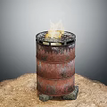 Rusty Oil Barrel With Burning Fire On Stones And Sand