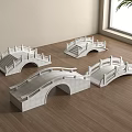 Four White Stone Arch Bridge Models Placed on Wooden Floor Near Window and Plant