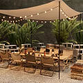 Canvas Tepee Tent With String Lights Tables Chairs And Green Plants On Gravel Ground