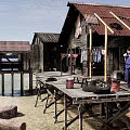Waterfront Stilt Houses With Wooden Platform Person In Blue Ladder Buckets And Tire
