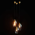 Three Glass Pendant Lights Hanging With Lit Warm Glow In Dark Background