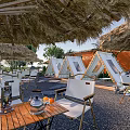 Serene Garden Landscape With Straw Umbrellas Deck Chairs Wooden Table Green Plants And Pebble Ground