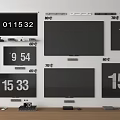 Multiple Televisions Mounted on Wall with Digital Number Displays and Devices Below
