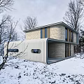 Modern Detached Villa With Curved Roof On Snowy Hillside And Illuminated Windows