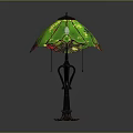 Decorative Table Lamp With Intricate Black Metal Base And Green Stained Glass Shade