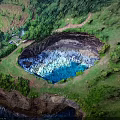 Natural Scenic Giant Blue Lagoon Surrounded by Lush Green Vegetation and Cliffside Grassland Path