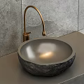 Round Stone Washbasin with Gold Faucet on Gray Wall Background