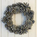 Succulent Wreath Decor with Mixed Green Pink Plants Hanging on White Wooden Wall