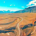 Scenic Wilderness View With Winding Road Distant Mountains Blue Sky White Clouds And Meandering River