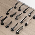 Black Door Handles In Various Styles Arranged On Wooden Tabletop