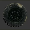 Muddy Off-Road Tire with Deep Tread Pattern and Black Wheel Rim