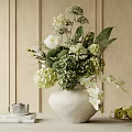 White Ceramic Vase with Fresh Mixed Flowers and Green Leaves on Wooden Table