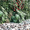 Living Plant Wall With Greenery Purple Red Flowers Deer Sculpture Pebbles And Bamboo
