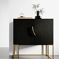 Black Textured Decorative Cabinet With Gold Legs And Green Plant Decor On Top