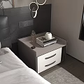 Bedside Table With Drawers And Stack Of Books On Light Top Near Black Leather Headboard