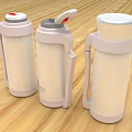 Three White Thermal Mugs With Different Lid Designs Handles On Wooden Tabletop