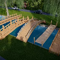 Scenic Wooden Landscape Bridge Over Water With Green Grass And Willow Trees