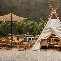 Canvas Tepee Tent With String Lights Tables Chairs And Green Plants On Gravel Ground