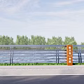 Metal Railing With Glass Panels Along Riverside Road And Green Vegetation