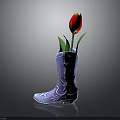 Blue Cowboy Boots with Star and Pattern Decorations Used as Flower Vase Holding Red Tulip