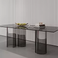 Modern Glass Top Coffee Table With Black Cylindrical Legs Featuring Fruit Bowl And Stacked Books