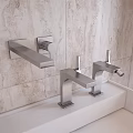 Sleek Modern Bathroom Faucets On White Countertop With Beige Tile Backdrop