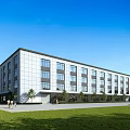 Modern Industrial Factory Building With White Facade Large Windows Green Lawn And Trees