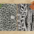 Two Square Rugs With Black And White Fan And Leaf Patterns On Wooden Floor