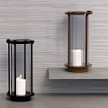 Black And Brass Candle Lamps With White Candles On Gray Shelf Against Gray Wall