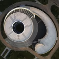 Contemporary Museum Building Featuring Circular Design And White Geometric Facade In Green Surroundings