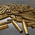 Pile of Brass Bullets Scattered on Ground as Weapon Ammunition Stock
