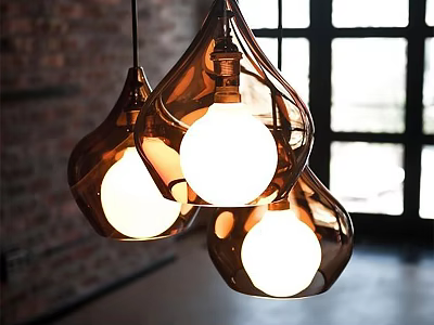 Three Amber Glass Teardrop Pendant Lights Hanging In Bright Interior With Brick Wall 3d model