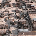 Arid Desert Military Camp With Tents Watchtowers Vehicles And Sandbag Fortifications