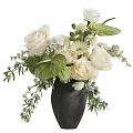 Floral Arrangement in Black Vase With White Roses Green Leaves And Small Flowers