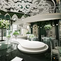 Elegant Banquet Hall With Ornate Ceiling Spiral Staircase Round Platform And Clear Chairs