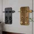 Black And Gold Decorative Door Knockers With Carved Patterns On Wall And Green Plants