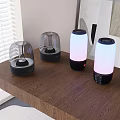 Multiple Desktop Speakers with Transparent Dome and Colorful Lights on Wooden Tabletop Near Window Artwork