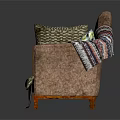 Brown Sofa With Various Patterned Pillows And Striped Blanket On Wooden Armrests
