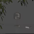 Minimalist Transparent Glass Shade Table Lamp With Metal Base And Green Leaves