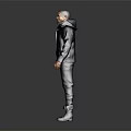 Man In Dark Hooded Jacket And Pants Standing On Gray Background With Boots